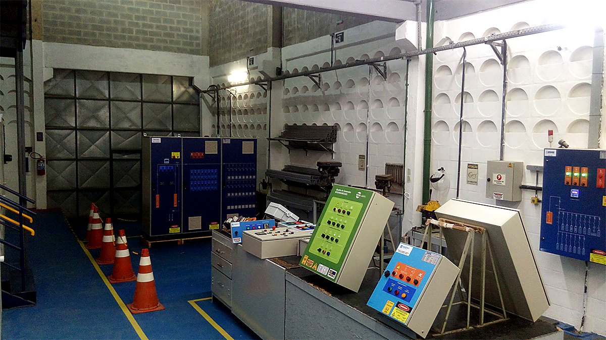 Área técnica com painéis elétricos e bancada de montagem